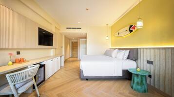 Een moderne hotelkamer met een bed, bureau en stoel.