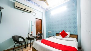 Une chambre d’hôtel équipée d’un lit, d’un bureau, d’une chaise et d’un appareil de climatisation.