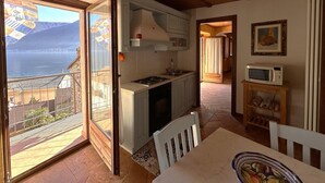 Cozinha com vista para o mar, mesa de jantar e micro-ondas.