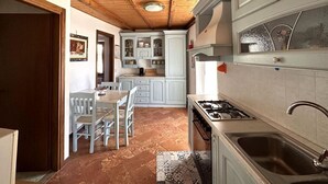 Uma cozinha com armários brancos, um fogão e uma pia.