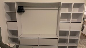 A bedroom with a bed, a wardrobe with multiple compartments, and a small table. - Gemütliche 3 Zimmer Wohnung in Wolfenbüttel Linden (Wolfenbüttel)