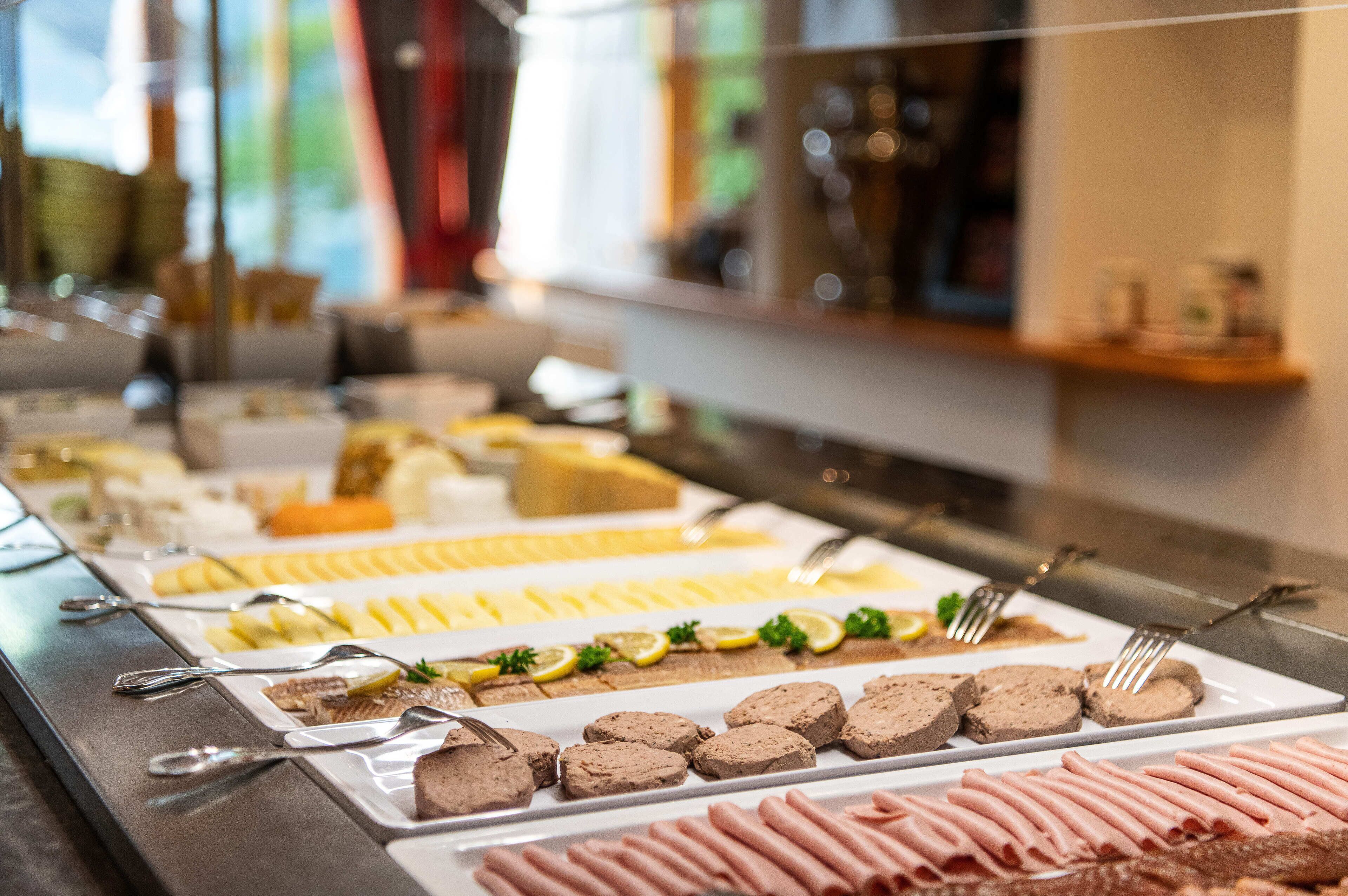 A buffet with various food items and utensils.