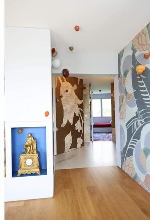 Cozy retreat with a vibrant mural, framed artwork, and a doorway to explore.