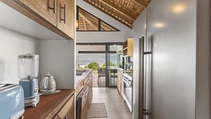 A modern kitchen with a built-in oven, a refrigerator, and a coffee maker.