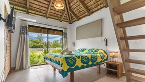 A bedroom with a bed, a window, a ceiling fan, and a view of greenery. - Seaside Haven: Expansive 3BR Villa in Moorea (Moorea)