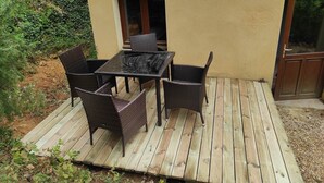 A wooden deck with a table and four chairs. - Chambre Familiale Périgord (VITRAC)