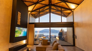 Un interior moderno con un televisor grande, asientos cómodos y vista al mar.