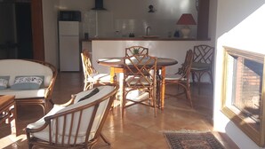 Un soggiorno accogliente con zona pranzo, mobili in legno e una cucina sullo sfondo.