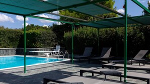 A swimming pool with lounge chairs and a covered area. - Villa Giorgisa Apartment 2 Pool Sea View (Ugento)