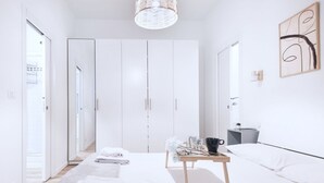 Un dormitorio moderno con cama, mesita de noche, armario y espejo.