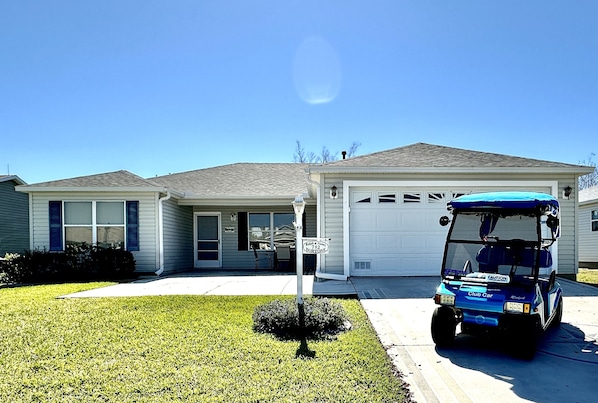 House Front View with Electric 2-Seater Golf Cart for Guest Use