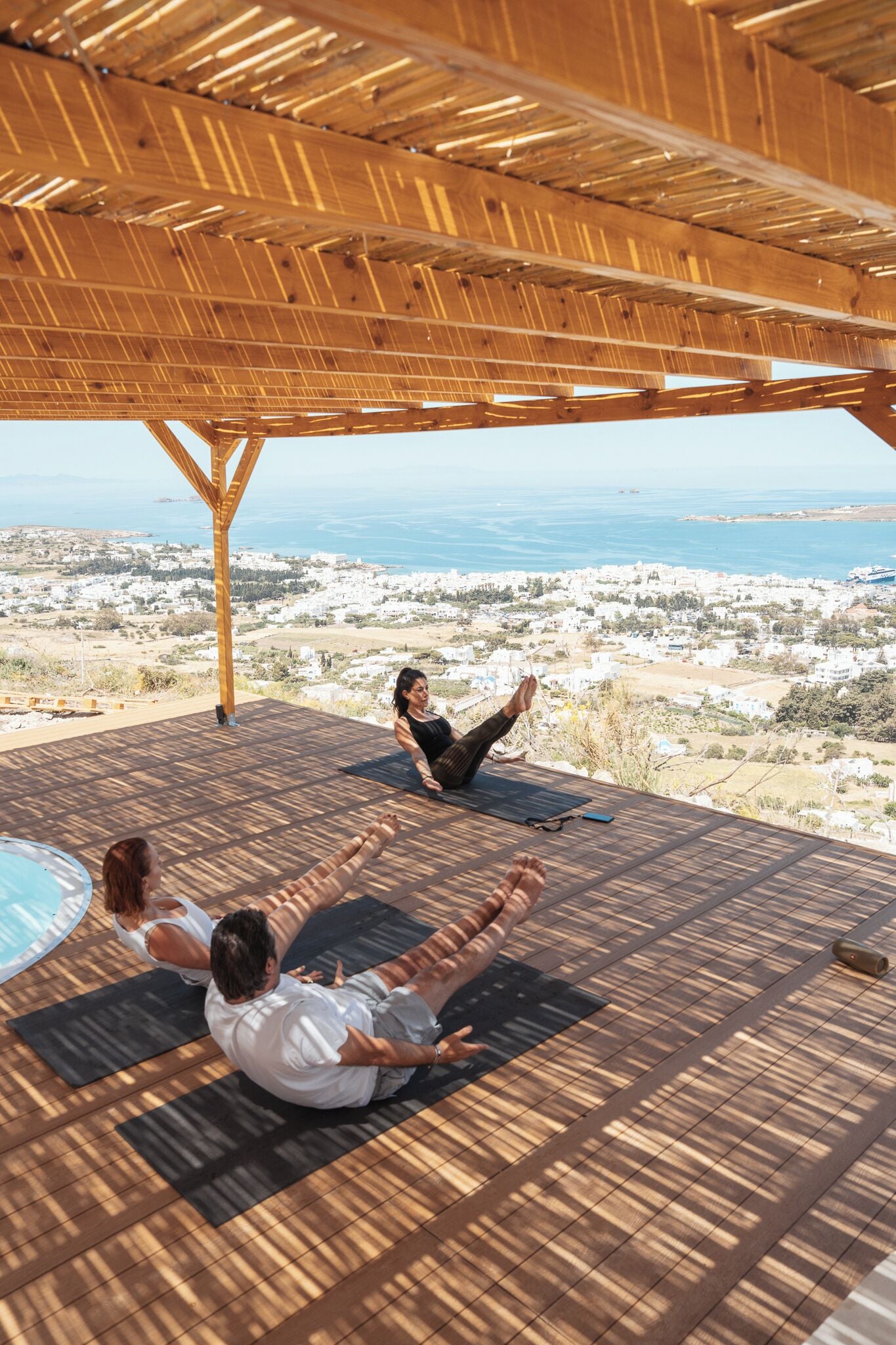 A wooden deck with a view of the sea and a town.