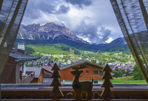 A view of a mountain town with wooden buildings and a prominent mountain range in the background.