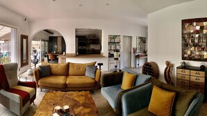 A spacious living room with a large TV, comfortable seating, a coffee table, and a view of the outdoors. - Maison Avec Piscine (Saint-Raphaël)