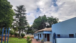 Il s’agit d’une propriété résidentielle comprenant une maison bleue, une allée pavée et une pelouse bien entretenue.