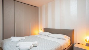 A hotel room with a bed, a wardrobe, and a nightstand. - Il Balcone in centro di Via Manzoni (Barzio)