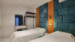 A hotel room with two single beds, a wooden panel wall, a mirror, and a built-in shelf. - Vila Eduart (Ksamil)