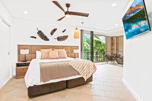 A bedroom with a bed, nightstands, a ceiling fan, a TV, and a view of the outdoors. - 234 Temple Tranquility: Triton Retreat- Luxury Palm Cove Apartment with Resort Pool & Oversized Balcony (Palm Cove)