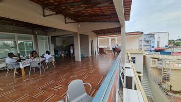 A covered outdoor area with a tiled floor, tables, and chairs.