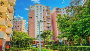 A residential building with multiple floors, balconies, and a well-maintained garden area. - Remarkable 5-bed Apartment in Kilamba - Luanda (Belas)