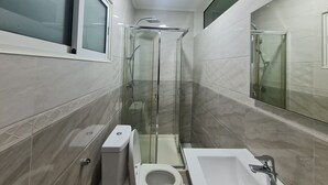 A compact bathroom with a glass-enclosed shower, a toilet, and a bathtub. - Guest House Sleeps 14 With Terrace (Luanda)