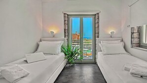 A room with two beds, a laptop, and a potted plant. - Vista mare villas (Sitia)