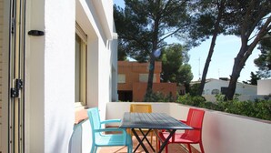 Eine Terrasse im Freien mit Tisch und vier Stühlen.
