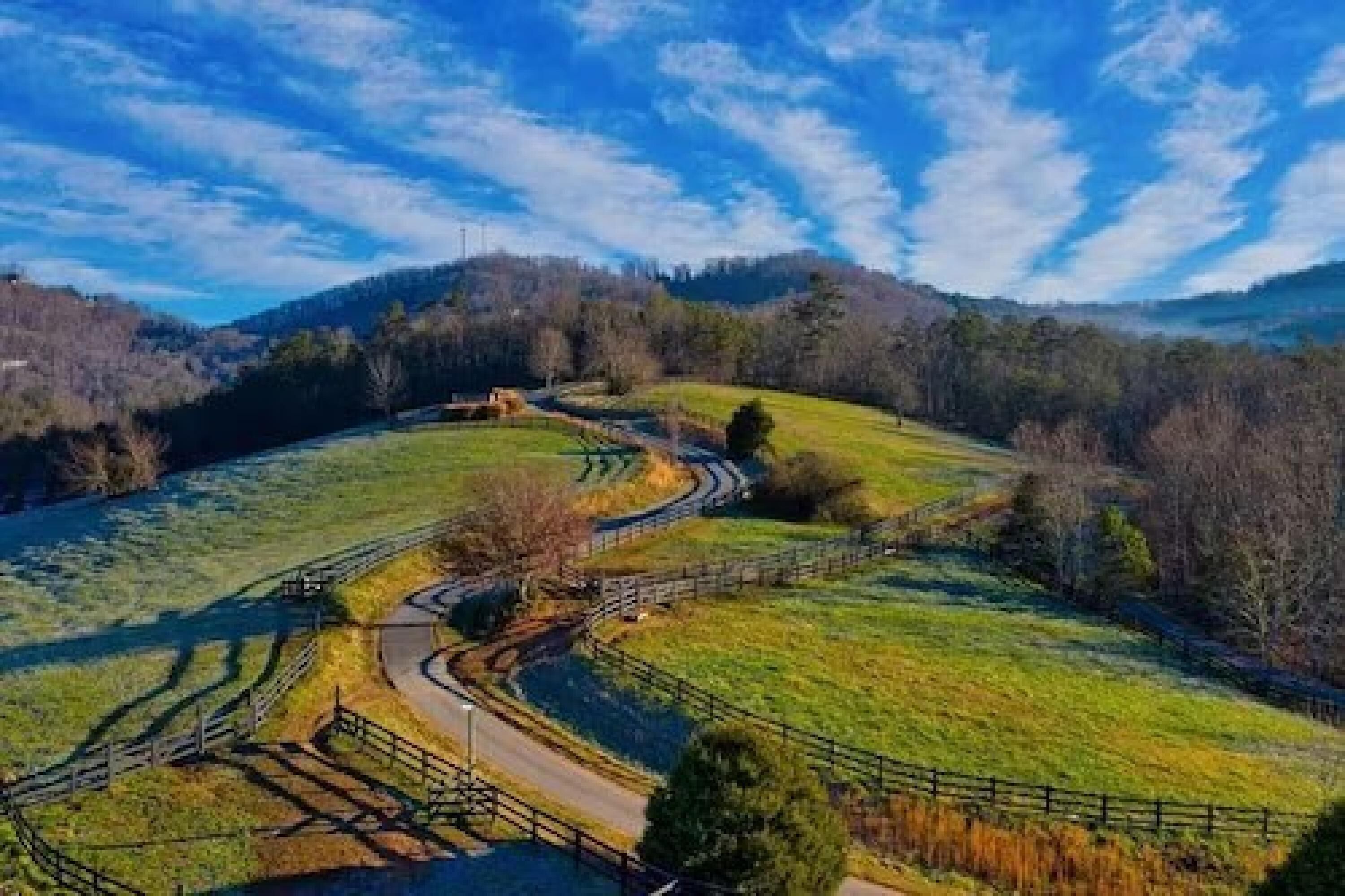 A winding road through a hilly landscape with a clear sky.