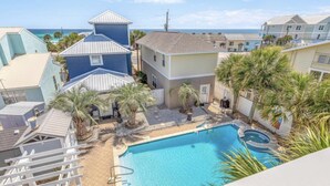 A residential area with a swimming pool, palm trees, and houses with various roof styles. - Modern Poolside Villa-steps to Beach (Panama City Beach)