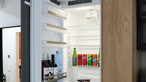 Una cucina moderna con frigorifero integrato, mobili in legno e un piano di lavoro.