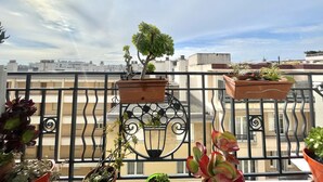A balcony with potted plants and a view of the cityscape. - The Artist (Cannes)
