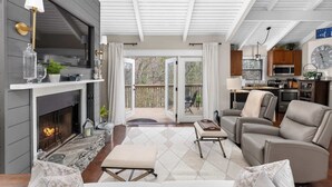 Una sala acogedora con chimenea, asientos cómodos y vistas a una terraza exterior.