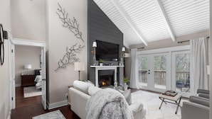Una sala de estar moderna con chimenea, un sofá y un comedor.