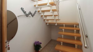 A modern staircase with wooden steps and a metal handrail, leading to a landing with a small potted plant. - Holiday apartment with 2 bedrooms and terrace (Banjole)
