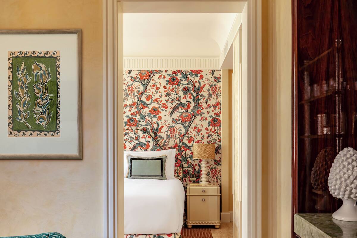 Une chambre à coucher avec un lit, une table de chevet et une œuvre d’art encadrée accrochée au mur.