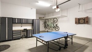 A room with a ping pong table, a bicycle rack, and a dartboard. - PGA West Getaway with Pool & Fire Pit (La Quinta)