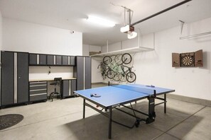 Et værelse med pingpongbord, cykelstativ og dartskive.
