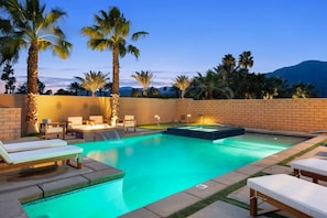 A swimming pool with lounge chairs, a hot tub, and palm trees. - PGA West Getaway with Pool & Fire Pit (La Quinta)