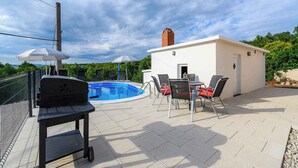 Une terrasse sur le toit avec une piscine, un barbecue et des sièges d’extérieur.