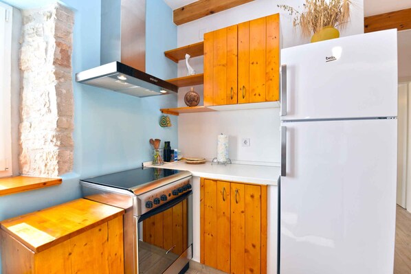 Réfrigérateur, un four, surface de cuisson, vaisselle et ustensiles