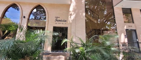 A building with arched entrances and a sign reading "Edificio Fenicia".