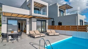 A modern two-story house with a swimming pool, outdoor seating, and a pergola. - Villa Saturday in Foinikas (Agios Vasileios)