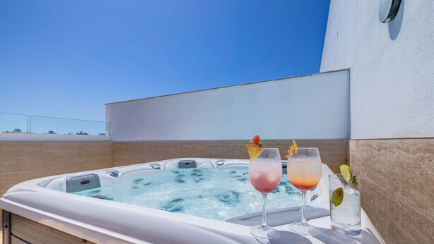 A hot tub with two drinks, one pink and one orange, and a lime wedge. - Red 6: Roof Top Studio Penthouse in St. Julian's (Swieqi)