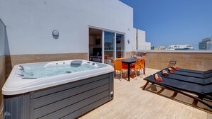 A rooftop terrace with a hot tub, outdoor seating, and a view of the city. - Red 6: Roof Top Studio Penthouse in St. Julian's (Swieqi)