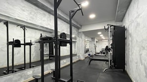 A gym with various exercise equipment, including a squat rack and benches. - Green 11: Two-Bedroom Apartment in St. Julian's (Swieqi)