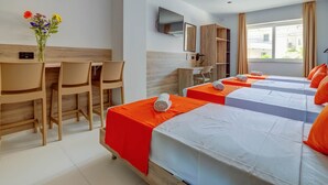 A hotel room with two beds, a desk, chairs, a TV, and a window with curtains. - Black 8: Studio Apartment in St. Julian's (Swieqi)