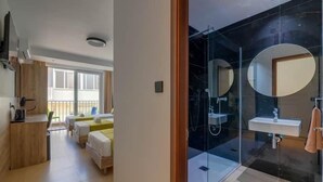 A modern hotel room with a kitchenette, a glass shower enclosure, and a view of the balcony. - Red 5: Studio Apartment in St. Julian's (Swieqi)