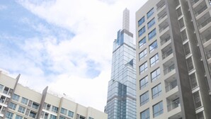 Um edifício moderno alto com fachada de vidro e várias varandas.