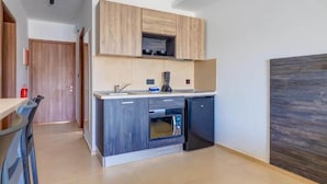 Een moderne keuken met een ingebouwde magnetron, een vaatwasser en houten kastjes.