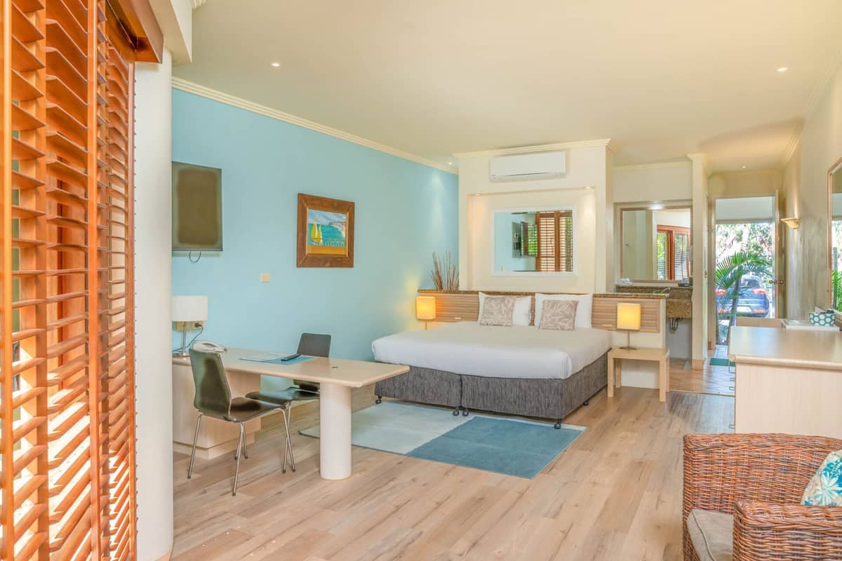 Una habitación de hotel moderna con cama, escritorio, silla y vistas al exterior.